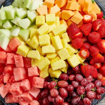 An assortment of freshly cut fruit including melons, strawberries, grapes, pineapple and other seasonal fruit