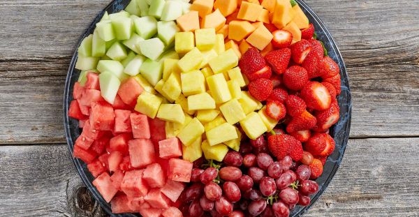 An assortment of freshly cut fruit including melons, strawberries, grapes, pineapple and other seasonal fruit