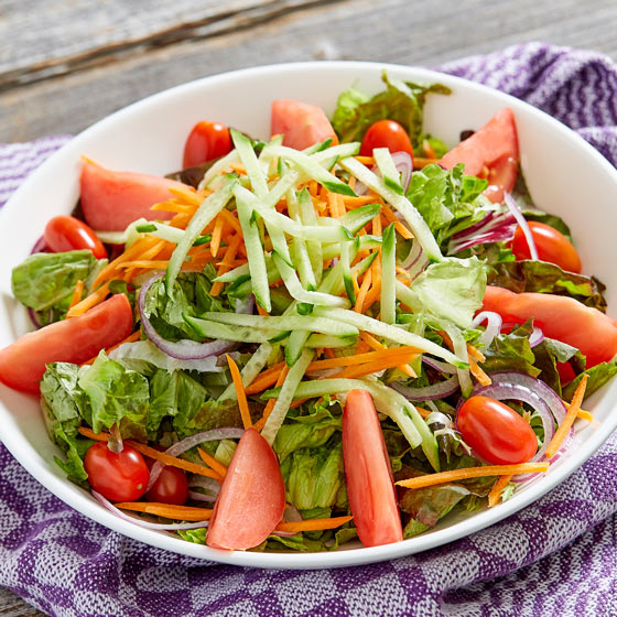 mixed green salad with mixed greens, tomato, grape tomatoes, onion, carrots and cucumbers